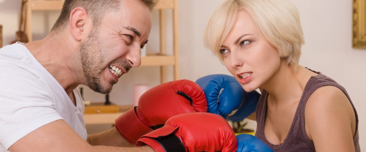 Family battle concept. Couple man and woman with red nad blue gloves on having battle at home. Handsome man and beautiful woman having fight all together.