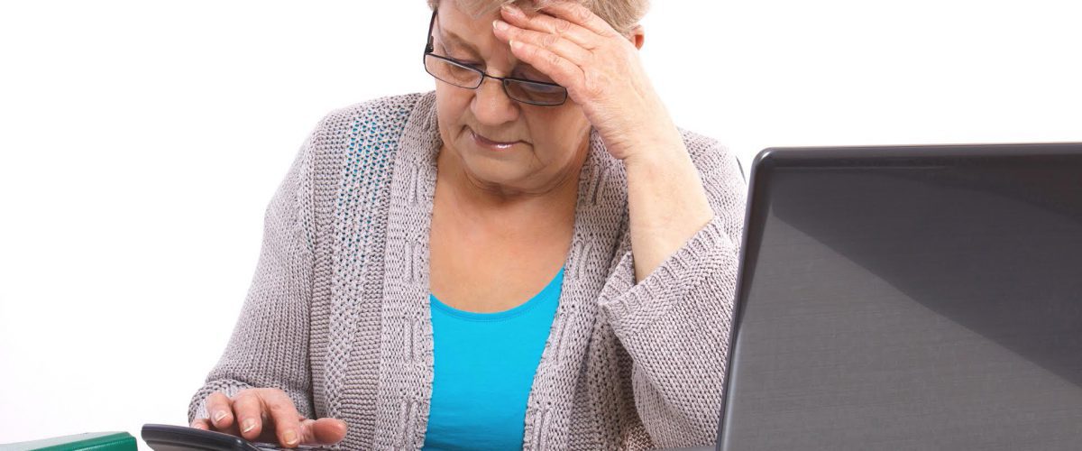 Worried senior woman, an elderly pensioner counting utility bills at her home, concept of financial security in old age