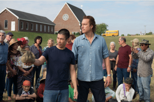 <em>In All Saints, actor John Corbett, portrays Rev. Michael Spurlock who welcomes refugees from Burma despite the financially failing state of his Tenn. country church. In this scene from the movie, Spurlock is seen with refugee Ye Win (portrayed by Nelson Lee), who served as a spokesperson for the refugees who were striving for a fresh start in America and needed healthcare, education, clothing and food. </em>