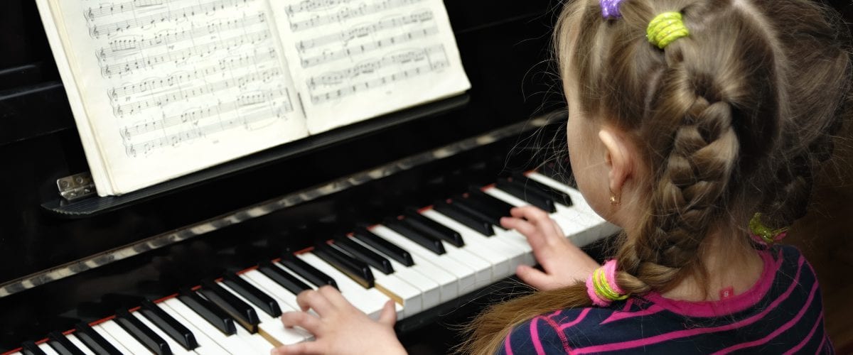 child plays on piano lesson of the music