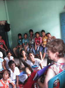 <em>Gloria Whitlock shows children living in India a picture book of salvation.</em>