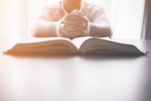 bigstock Man Praying On Holy Bible In T 226266571