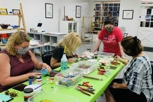 A Group of friends around a table creating art at Dixon Creative