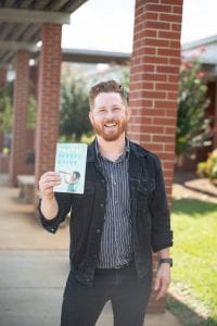 Ben Nelson holding his new book outside