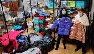 Ladies holding coats from the Prince of Peace Coat Drive