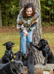 Sonya with black dogs on bench