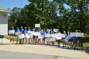 Royal Family Kids Camp volunteers holding signs