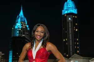 Cover story Carrington in red dress with city of Mobile behind her