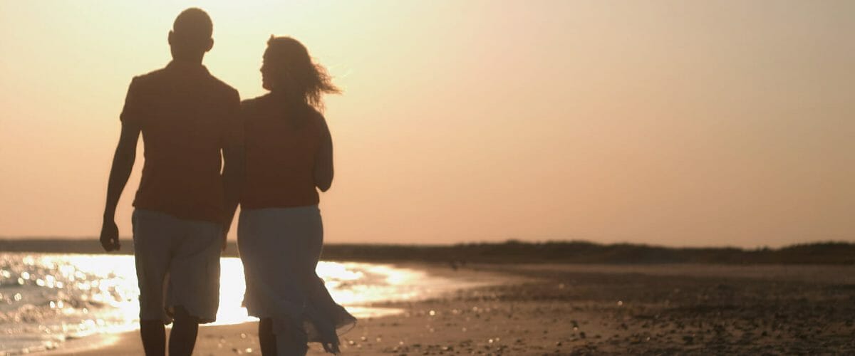 Couple Walking On Beach.