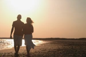 Couple Walking On Beach.