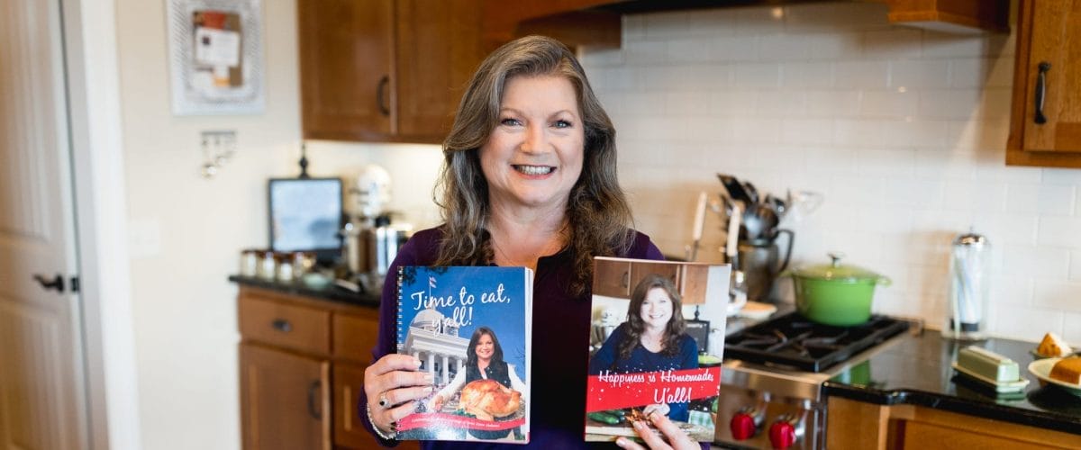 Danna holding cookbooks in kitchen