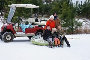 Merrell family in front of golf cart in snow