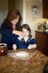 Danna and grandchild in kitchen with rolling pin