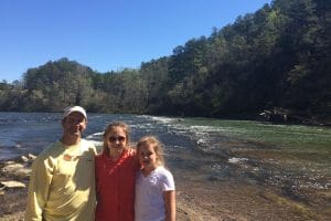 Walt and daughters standing in front of lake