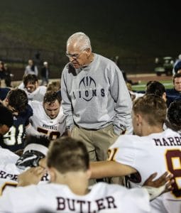 Coach Yancey in middle of team huddle