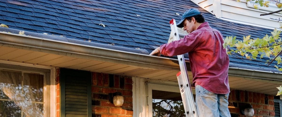 Man cleaning gutter Man cleaning gutter