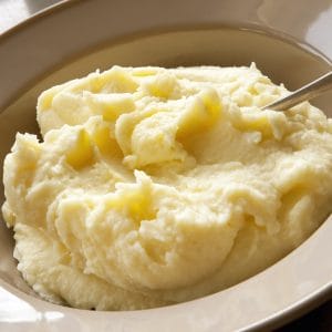 Mashed potato with spoon, in serving bowl.