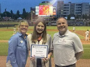 Scholarship winner at Barons with certificate