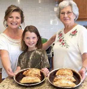 Danna with mom and granddaughter holding fried apple pies