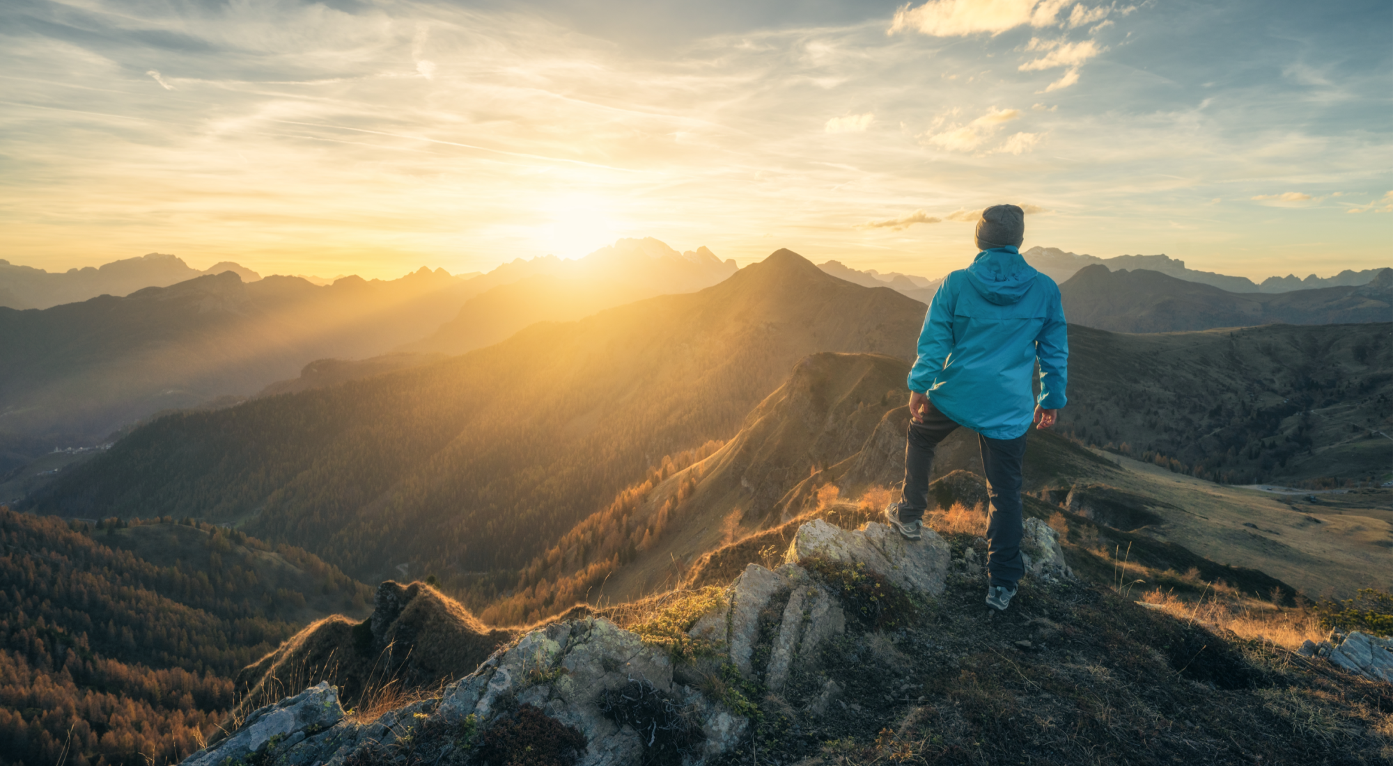 Man on top of mountain with sunrise